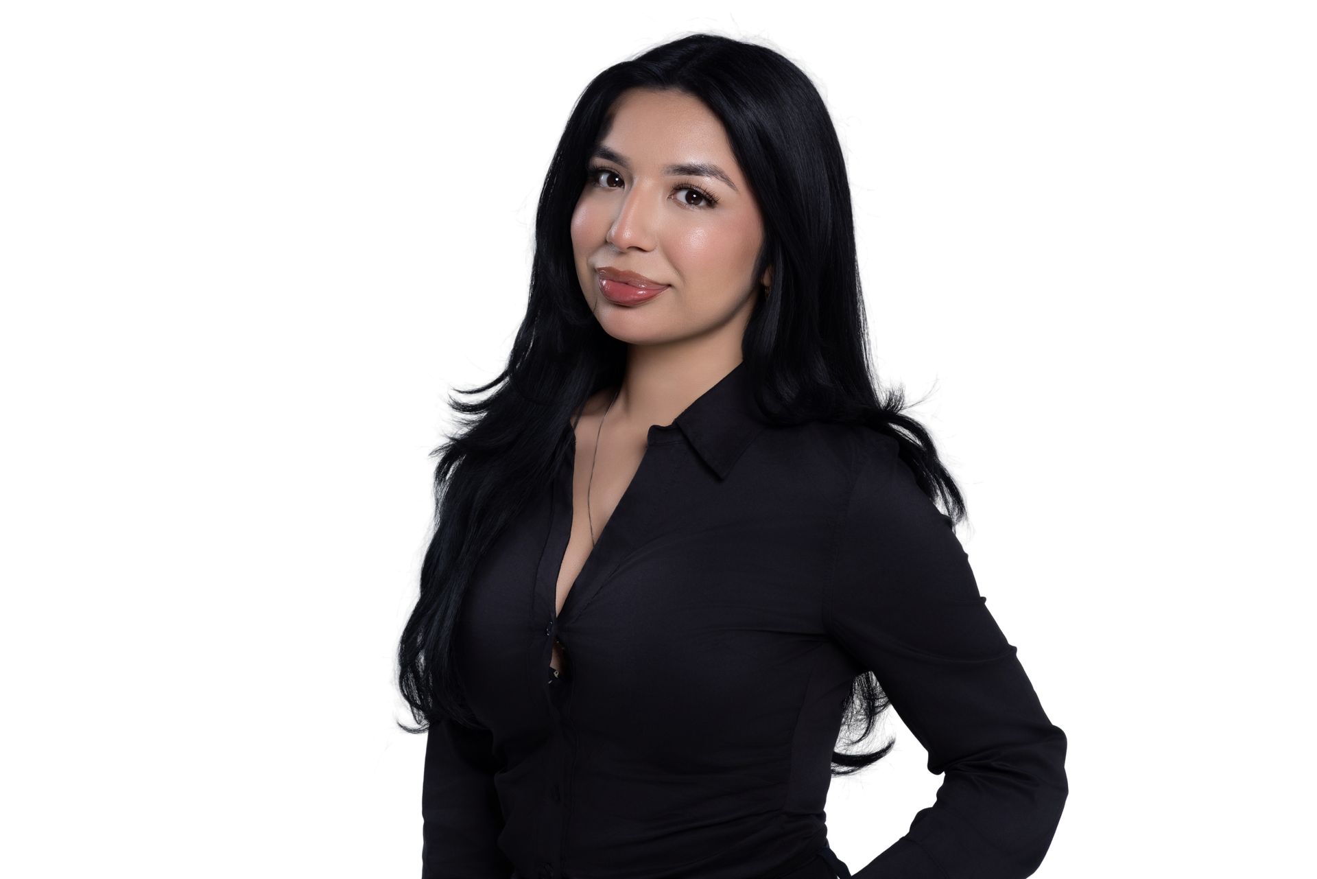 A person with long, dark hair wearing a black button-up shirt against a white background.