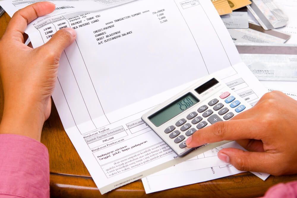 A person is using a calculator to calculate a bill