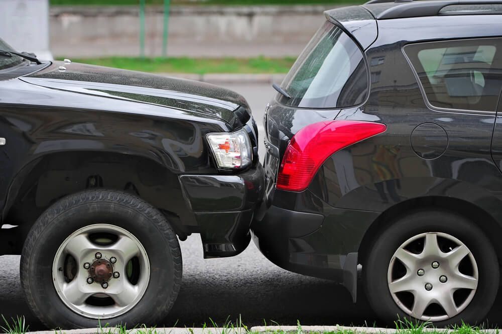 Two cars are parked next to each other on the side of the road.