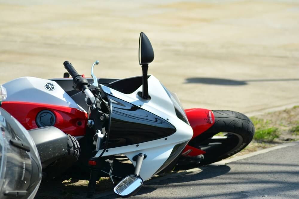 Two motorcycles are parked next to each other on the side of the road.