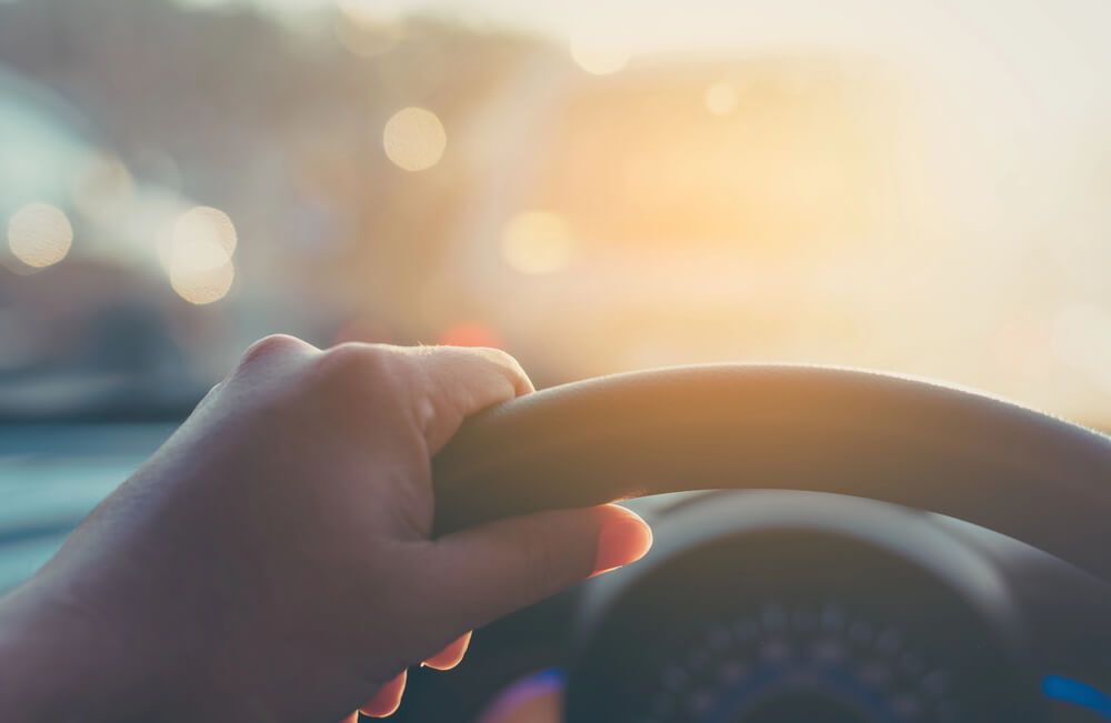 A close up of a person 's hand on the steering wheel of a car.