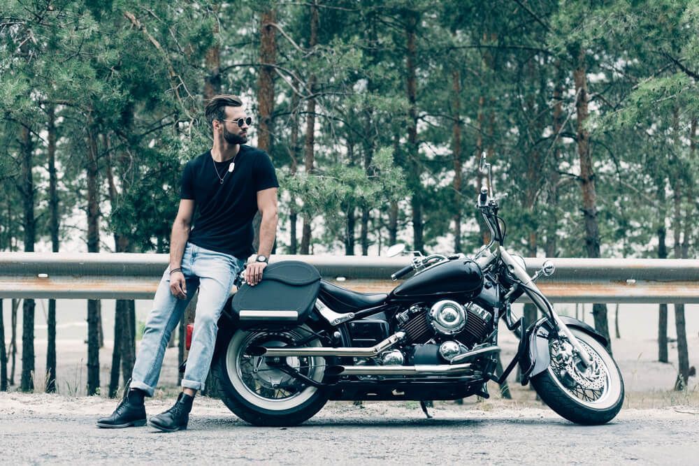 A man is sitting on the back of a motorcycle.