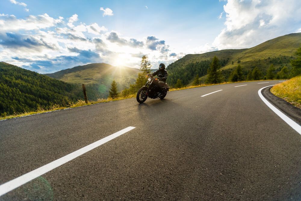 A person is riding a motorcycle down a curvy road.