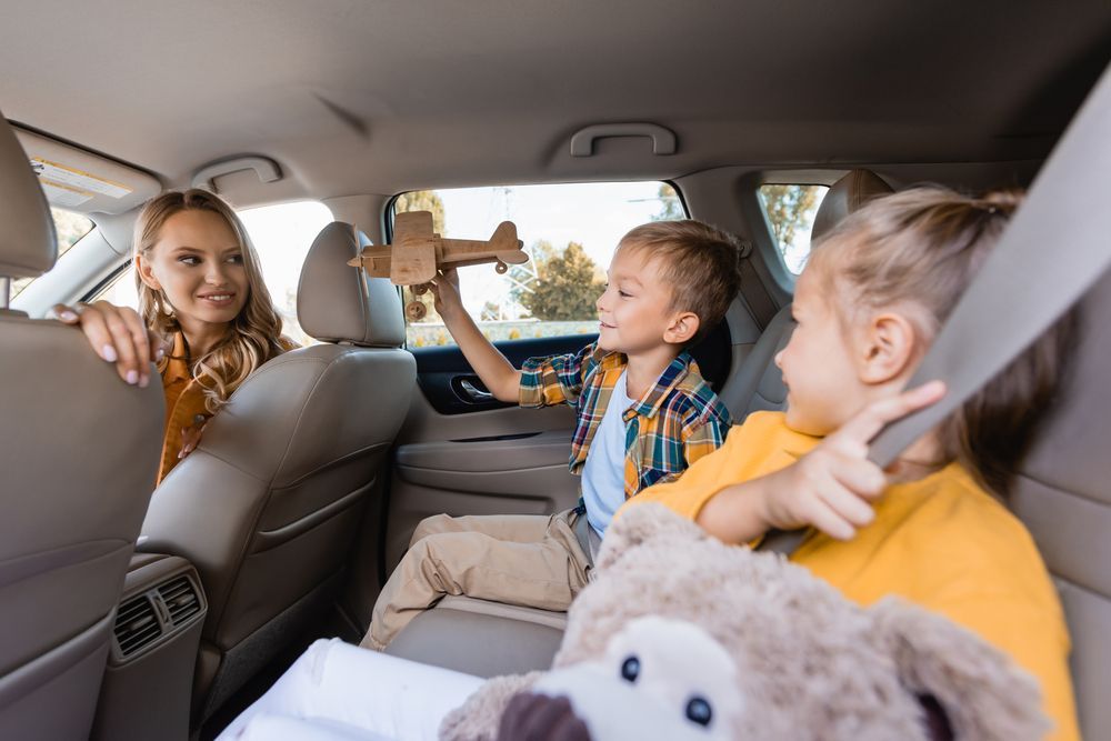 A group of children are sitting in the back seat of a car.