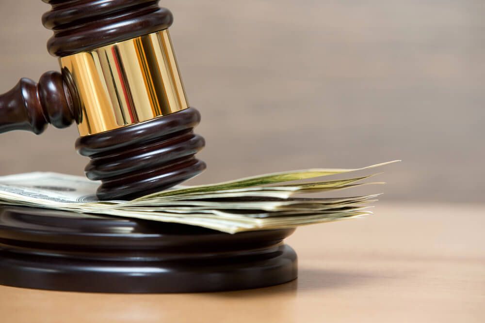 A judge 's gavel is sitting on top of a pile of money.