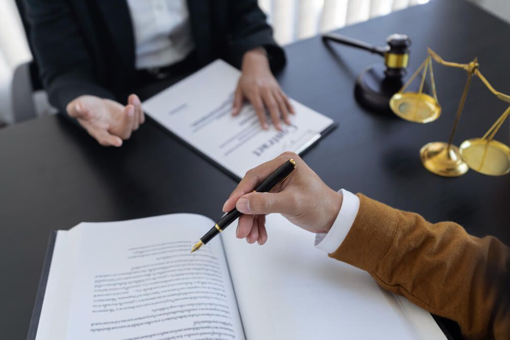 A person is writing on a piece of paper with a pen.