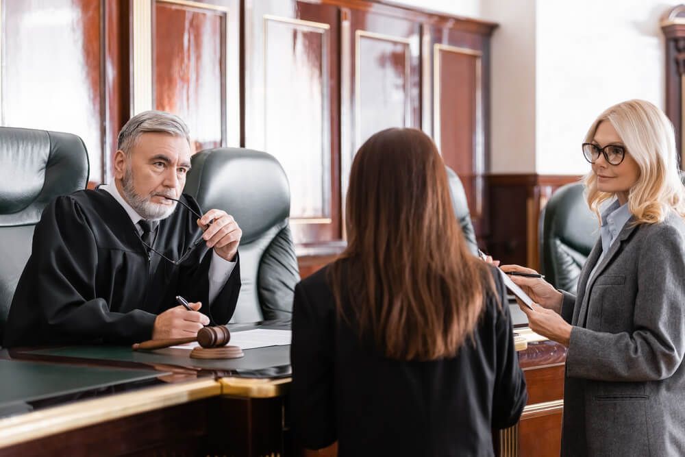 A judge is talking to a woman in a courtroom.