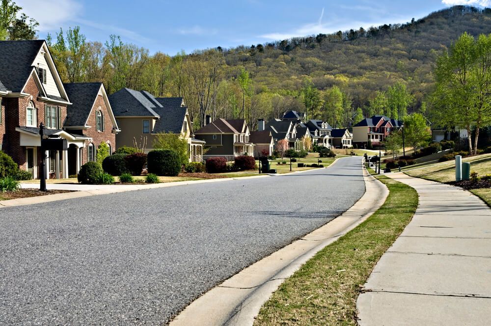 A row of houses on a residential street with a mountain in the background