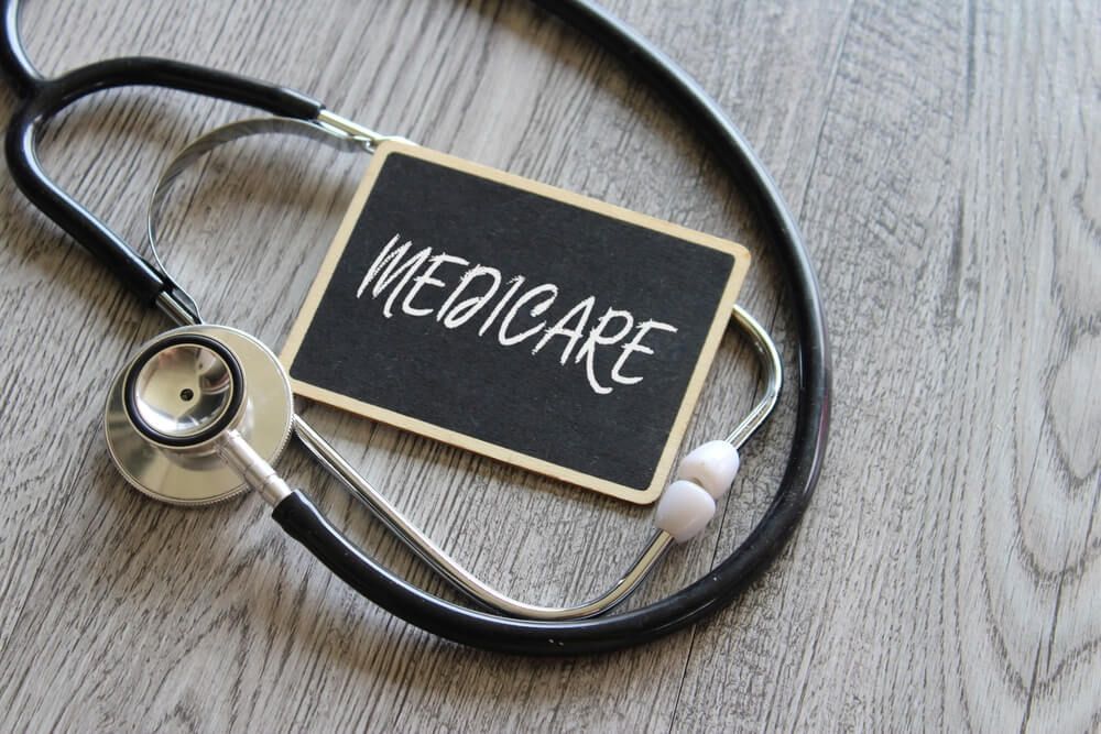 A stethoscope and a chalkboard with the word medicare written on it.