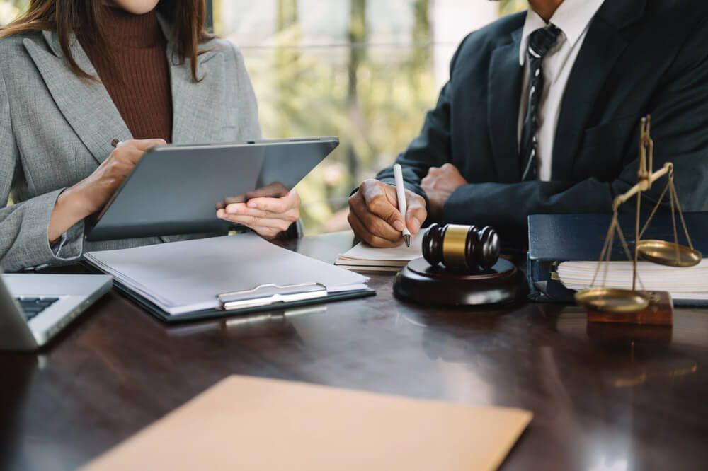 A man and a woman are sitting at a table with a judge 's gavel.