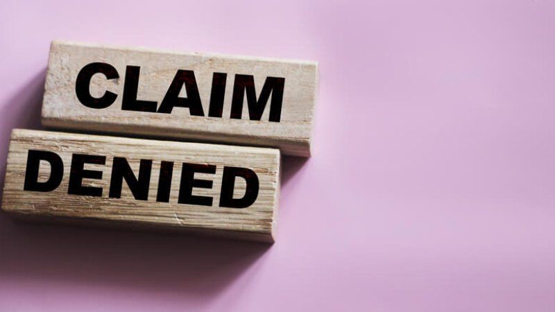 Two wooden blocks with the words claim denied written on them.