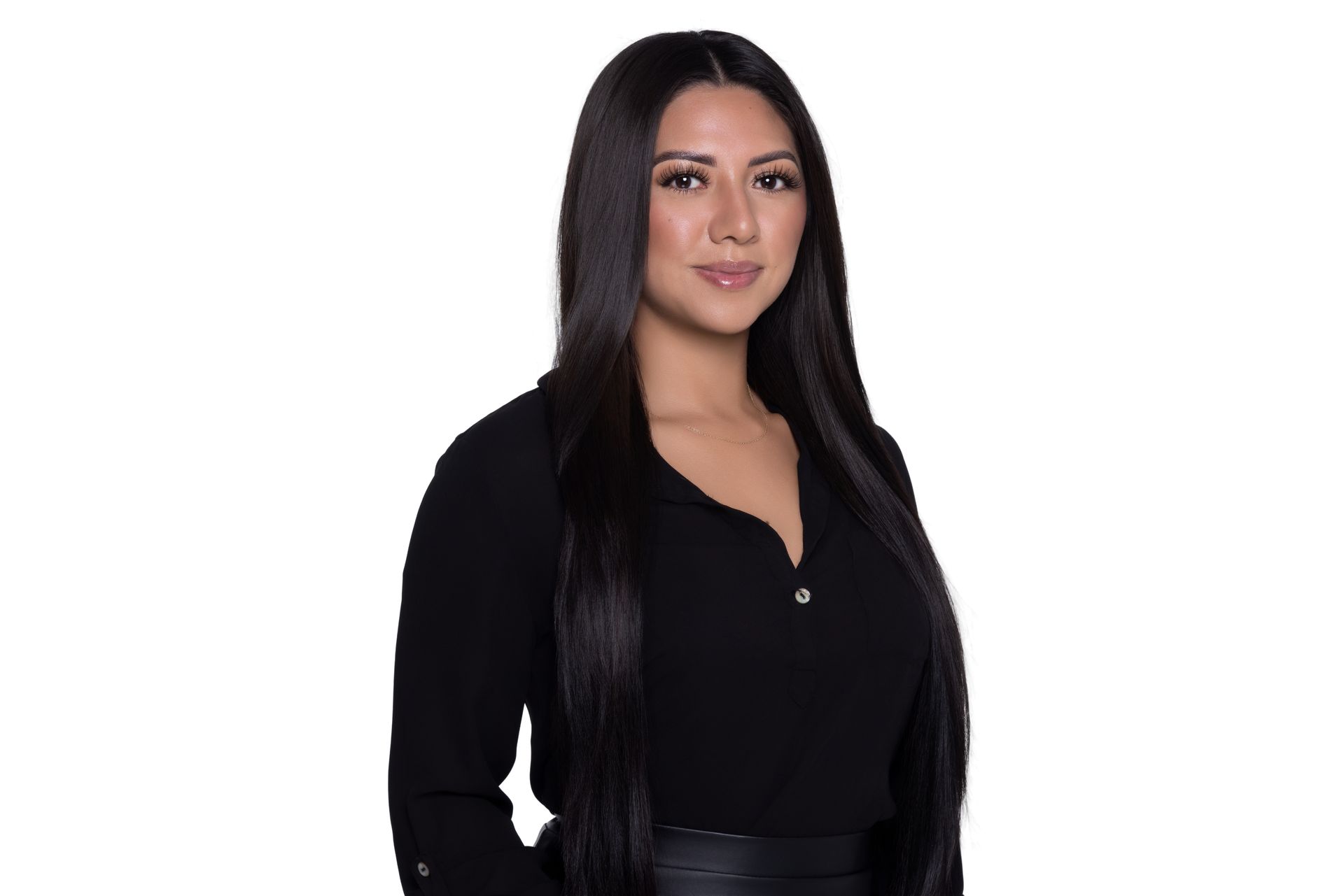 A woman with long dark hair, wearing a black collared shirt, against a plain white background.