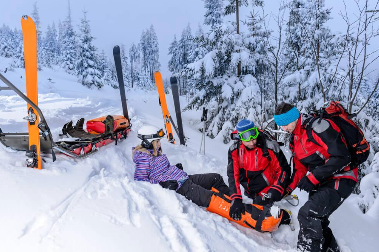 A person is laying on a stretcher in the snow.