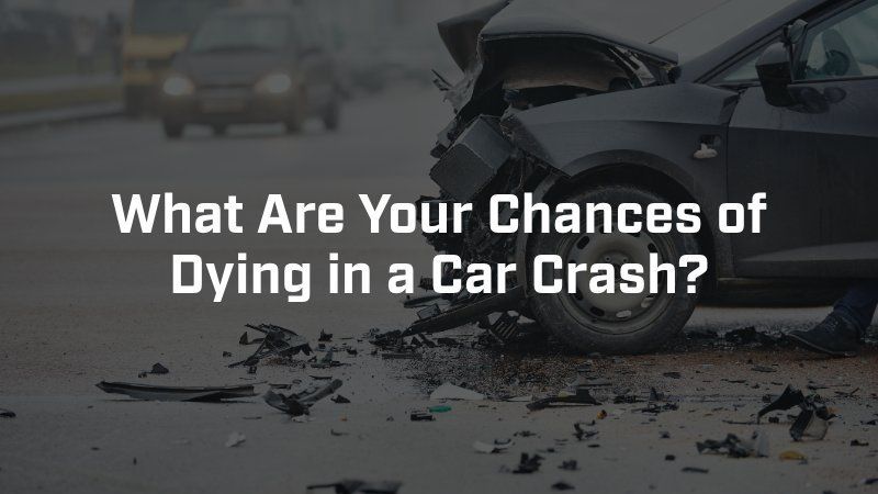 A dark, crashed car on a road, with the text