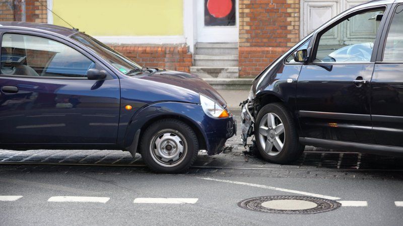 Two cars are involved in a car accident on the street.