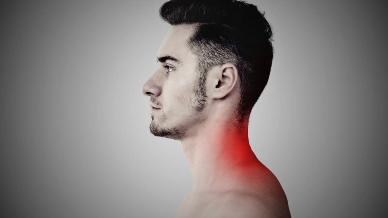 A man is without a shirt and has a red spot on his neck.