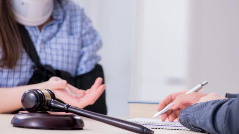 A man and a woman are sitting at a table with a judge 's gavel.