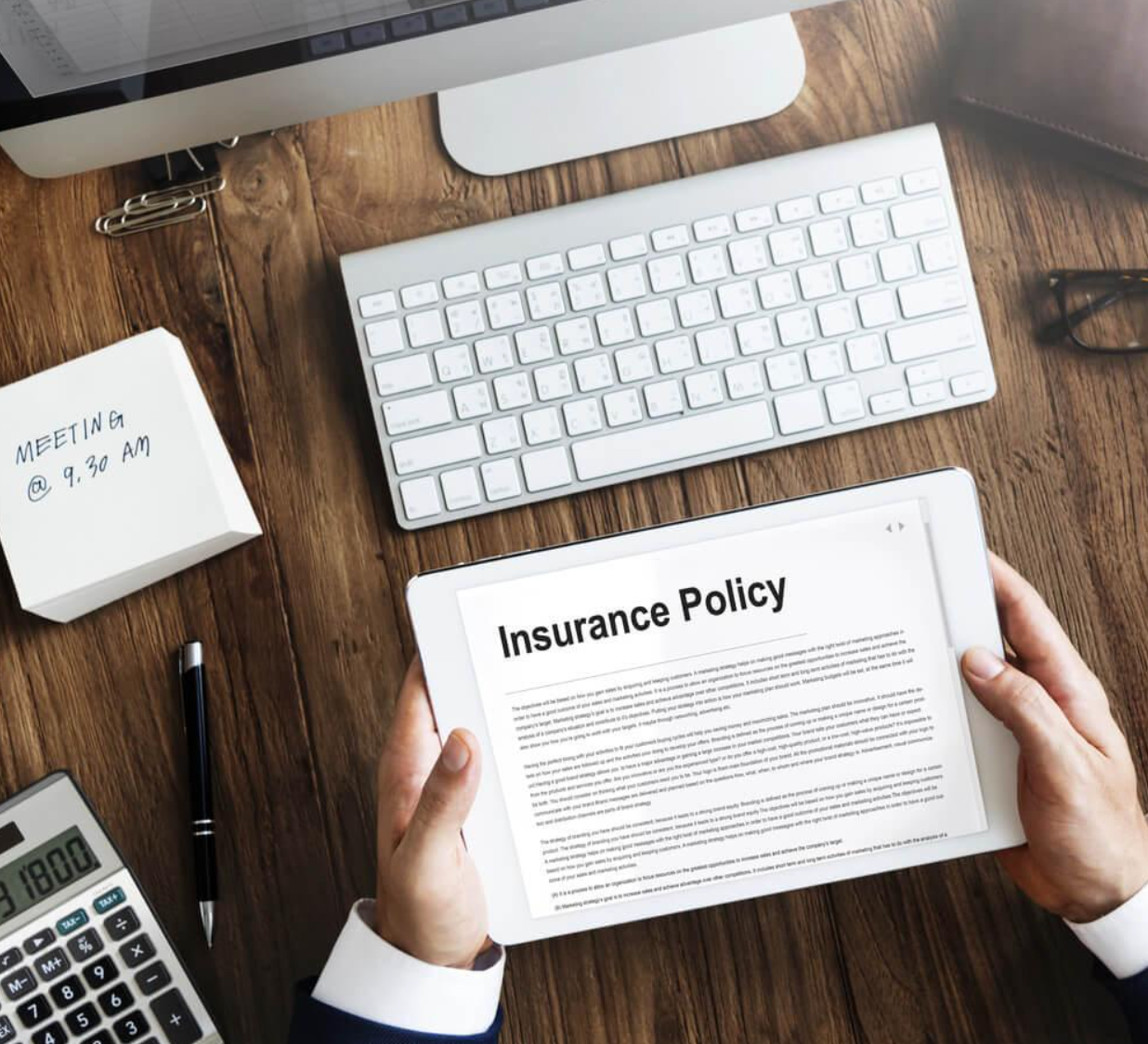 A person is holding a tablet with an insurance policy on it.