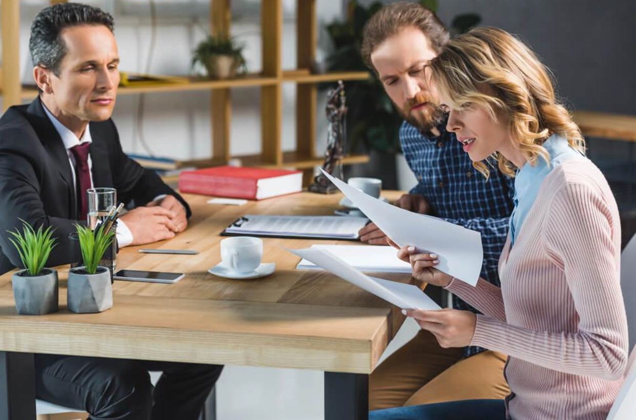A man and a woman are sitting at a table looking at papers.