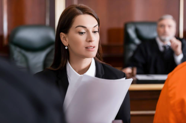 A woman is holding a piece of paper in a courtroom.