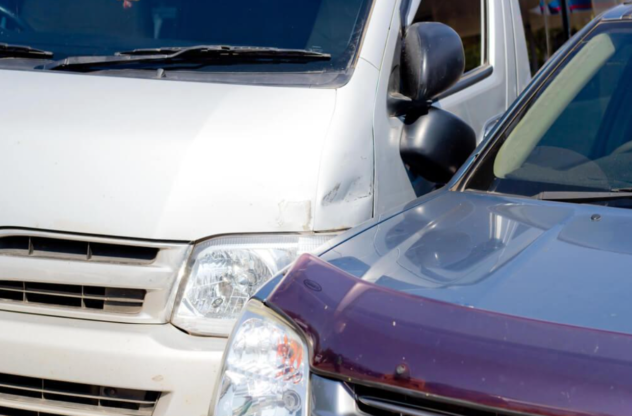 A white van and a purple car are parked next to each other.