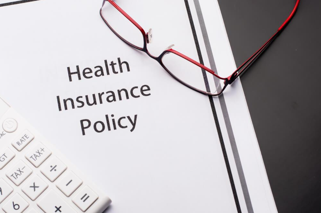 A health insurance policy with glasses and a calculator