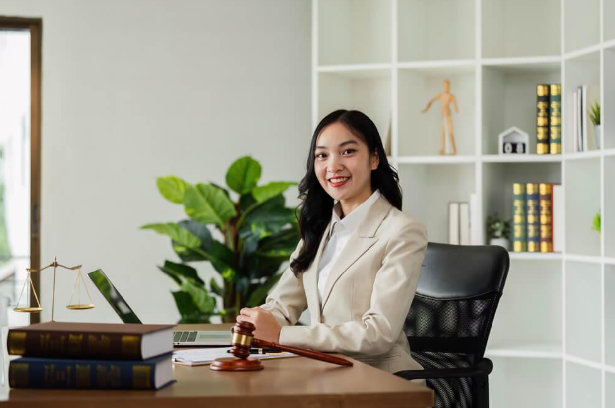 A woman is sitting at a desk holding a judge 's gavel.