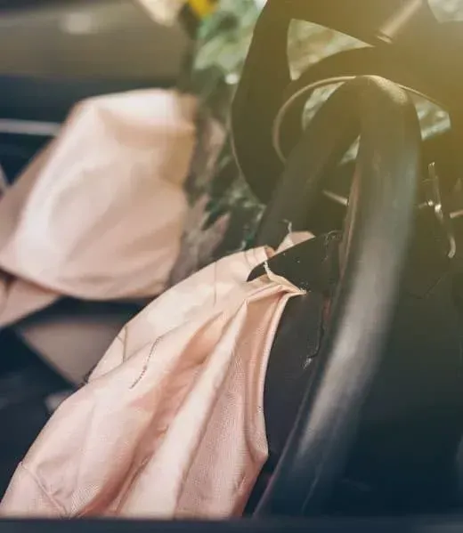 Deployed airbags in a car interior following a collision.