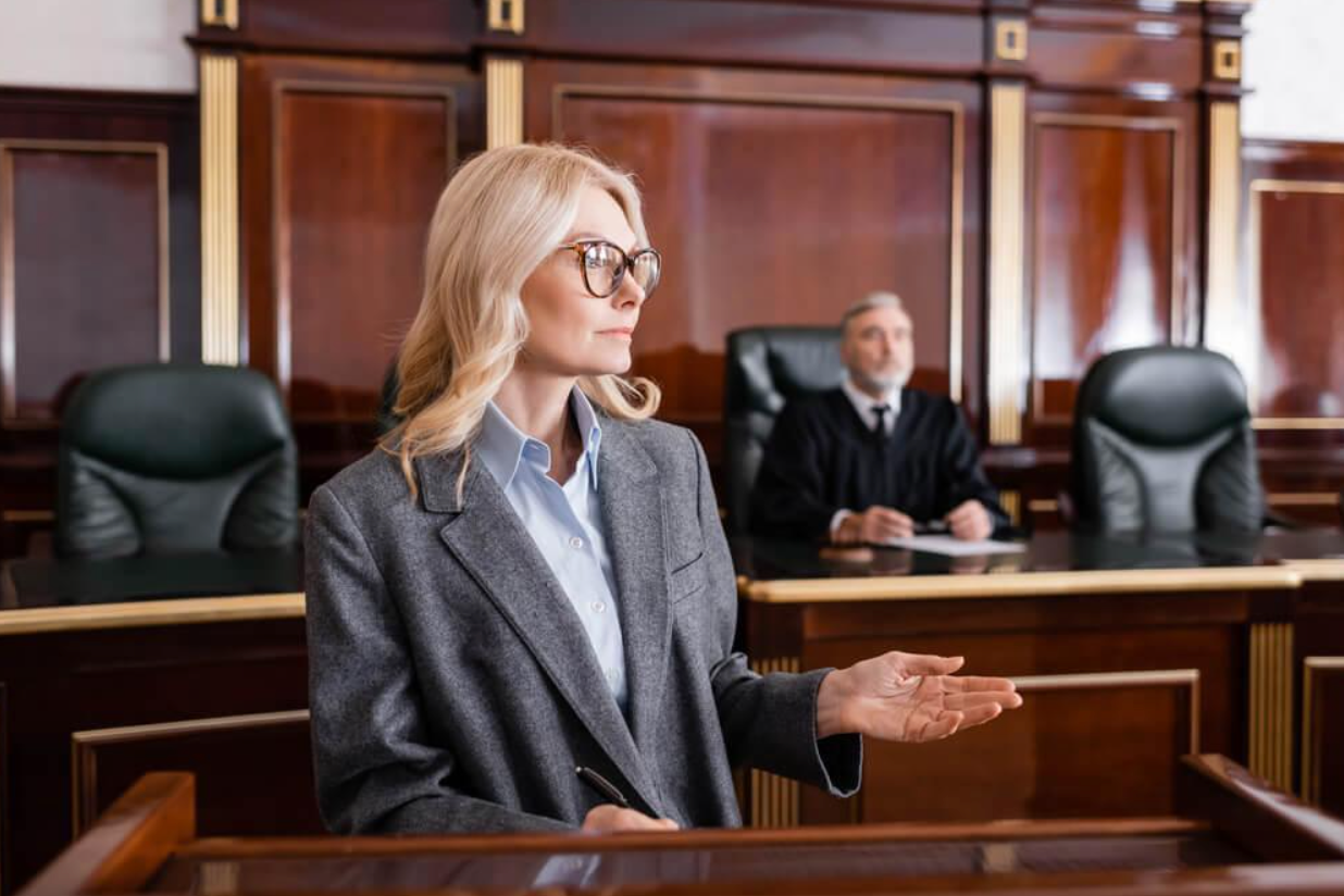 A woman is standing in front of a judge in a courtroom.