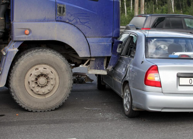 A car is being towed by a large truck.