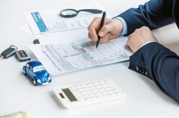 A man is sitting at a table writing on a piece of paper.