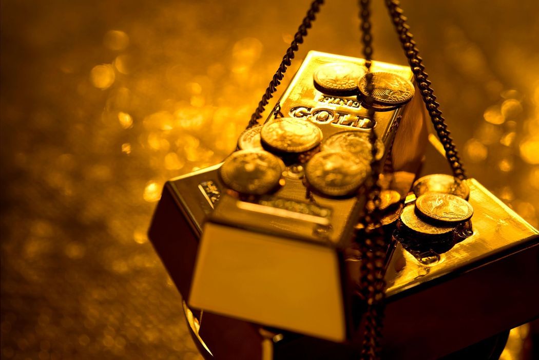 Monete d’oro che traboccano da uno scrigno del tesoro aperto su uno sfondo dorato