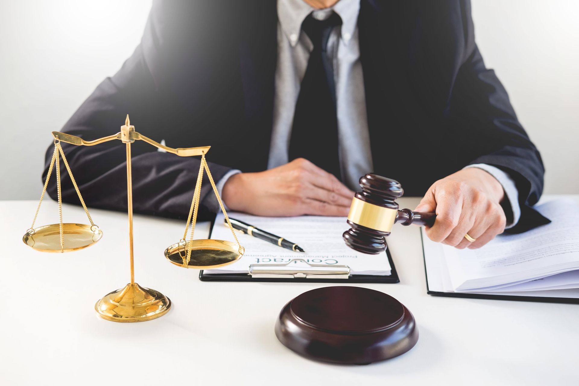 Lawyer at desk with scales, gavel, and legal documents in a bright office