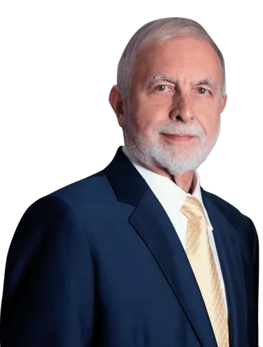 Studio portrait of a man in a navy suit and gold tie against a white background
