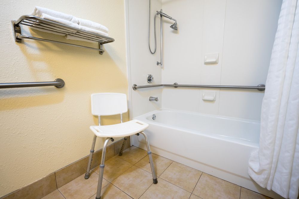 A Handicapped Bathroom With A Bathtub And A Chair — My Coast Projects in West Gosford, NSW