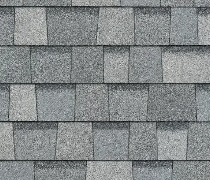 Gray asphalt roof shingles arranged in overlapping rows