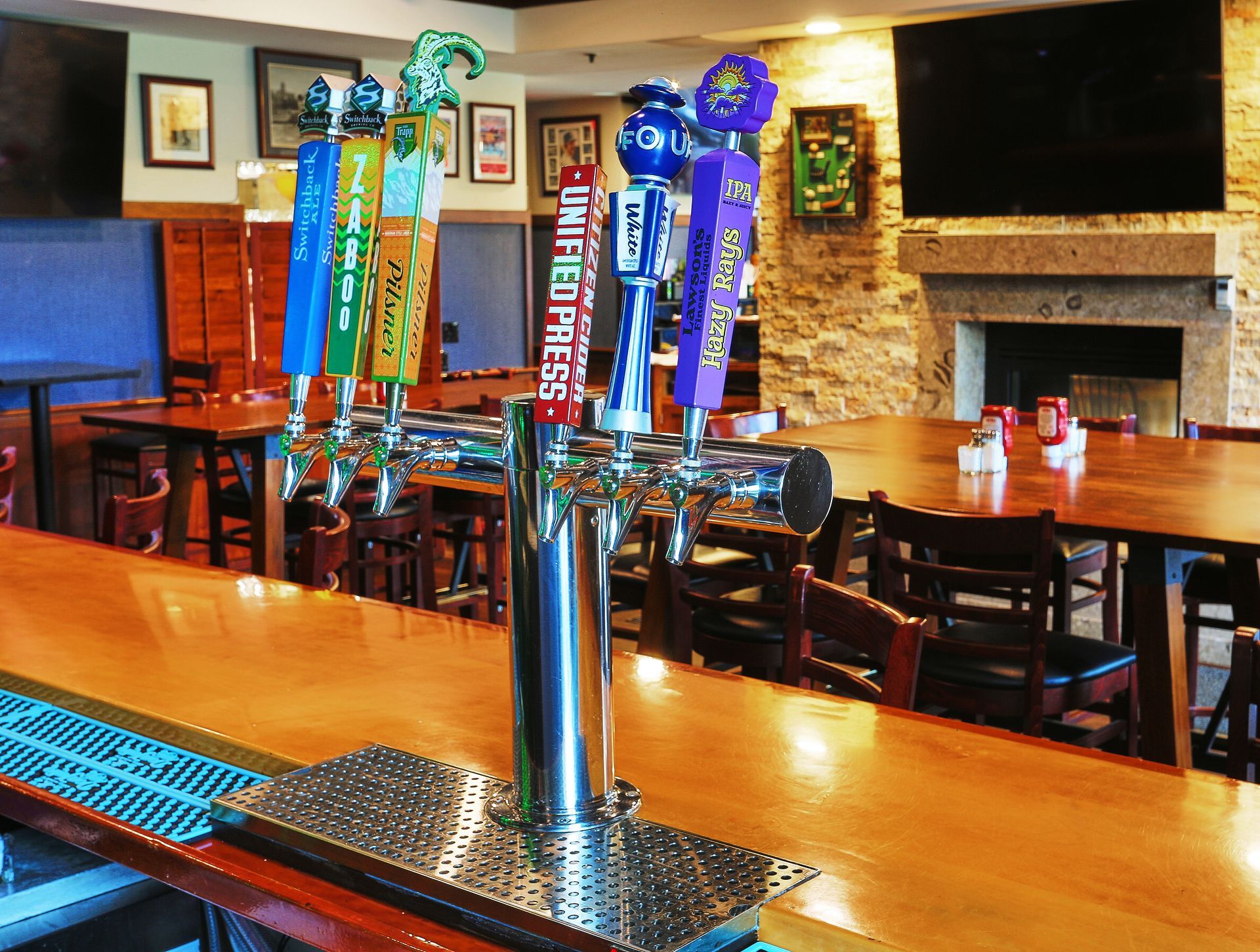 a row of beer taps in a restaurant including one that says unleashed