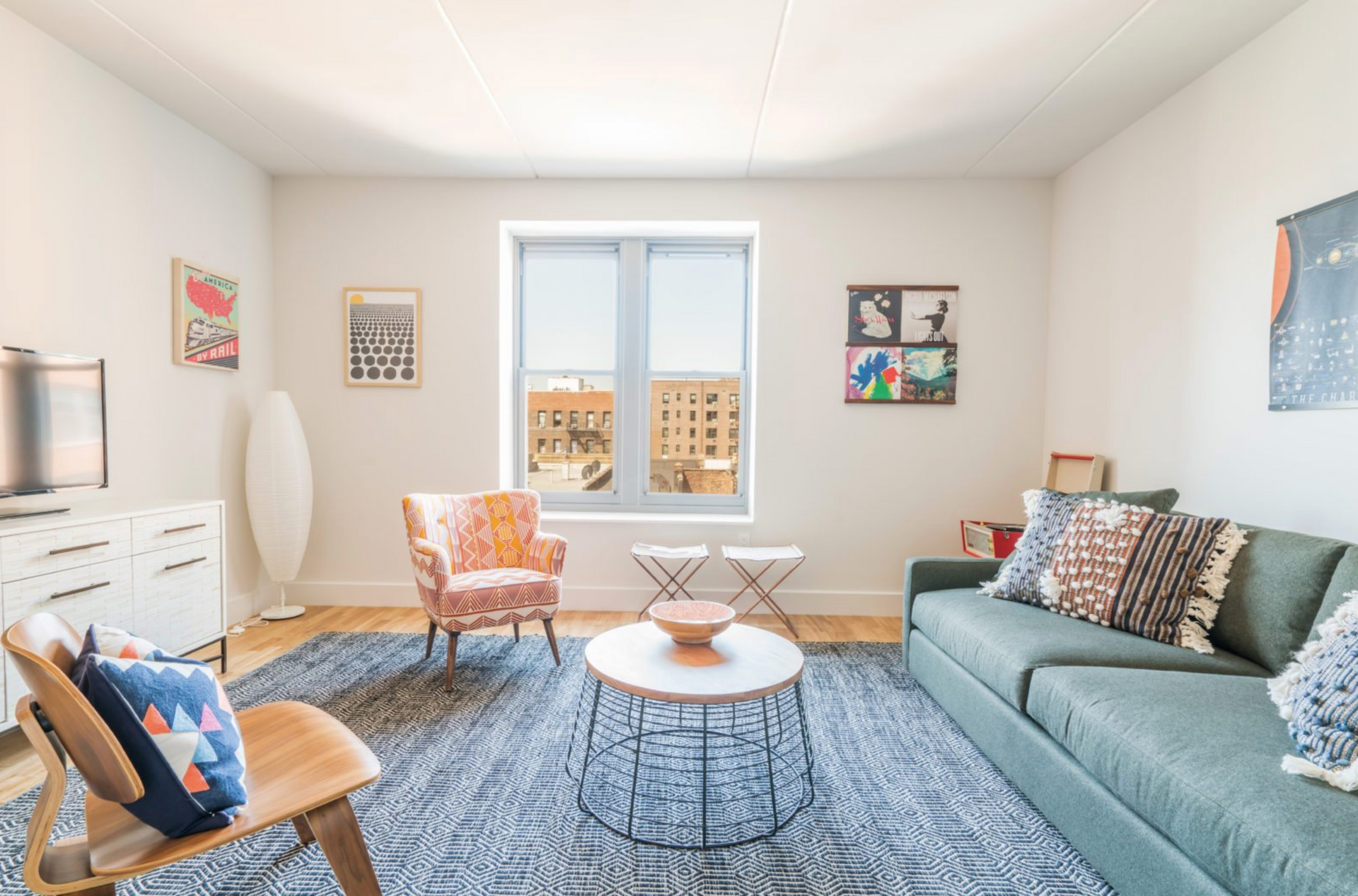 a living room with a couch , chairs , a table and a television .