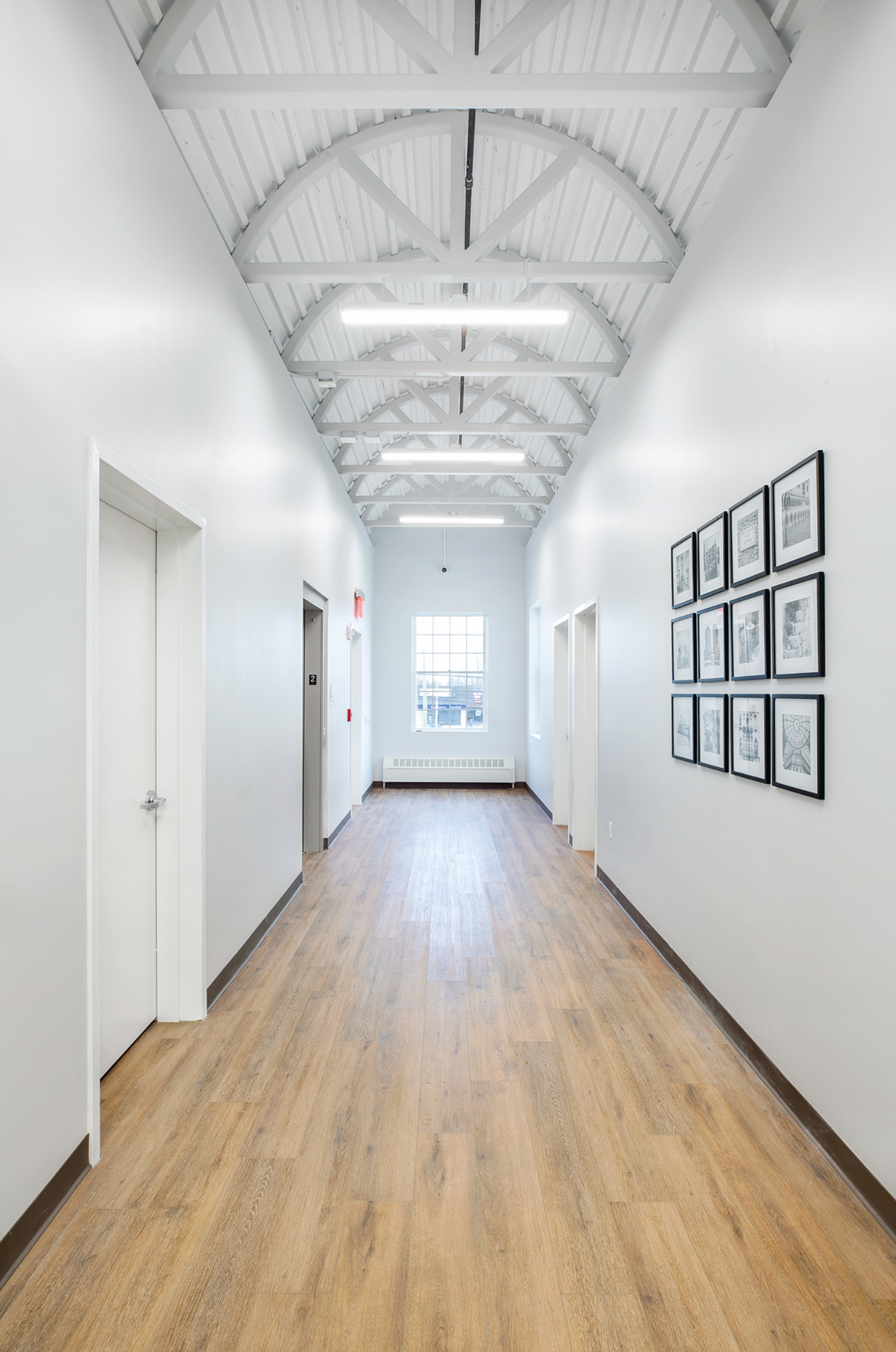 a long hallway with wooden floors and white walls .