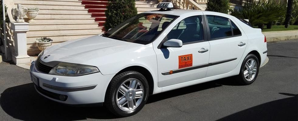Un taxi bianco è parcheggiato davanti a un edificio.