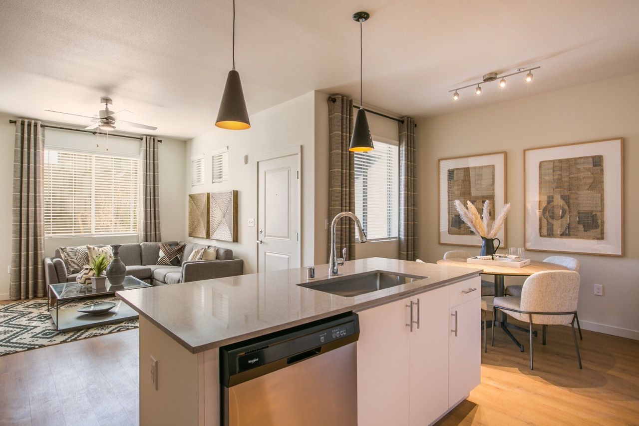 Open-concept kitchen with island and living area in an apartment.