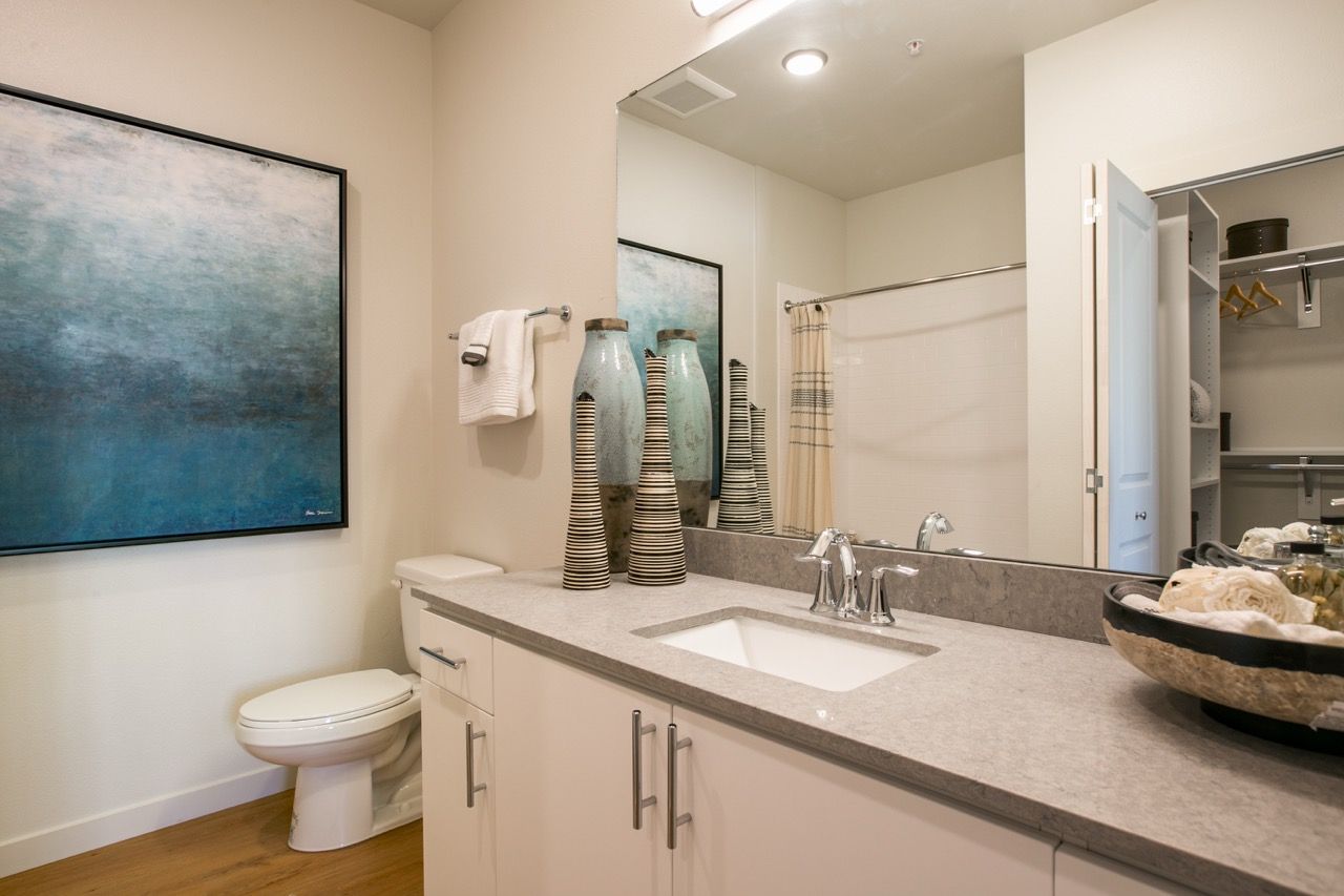 Bathroom vanity with sink, mirror, and storage cabinets.