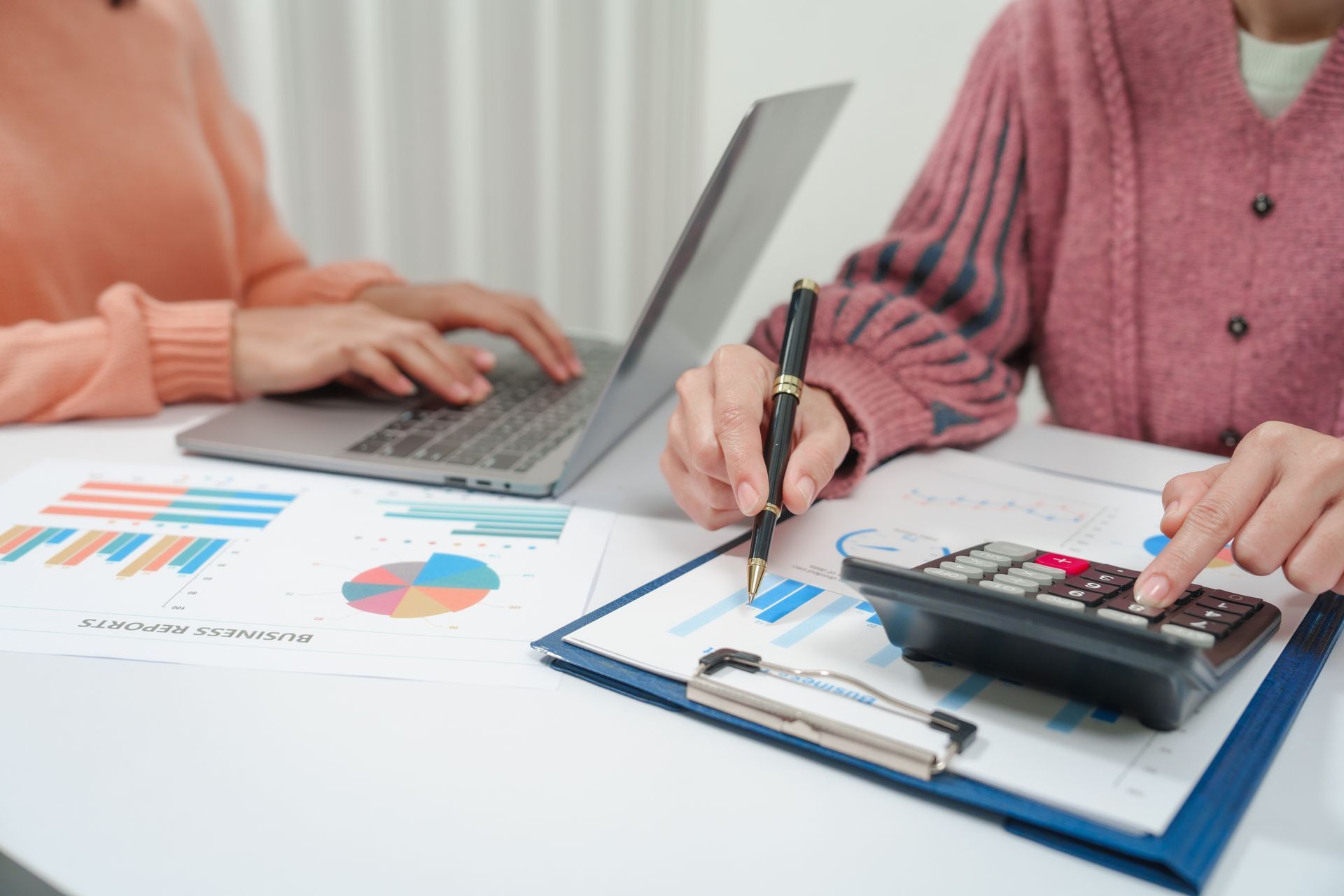 Small business cash flow analysis with charts, calculator, and laptop during financial review. Small business cash flow analysis with charts, calculator, and laptop during financial review.