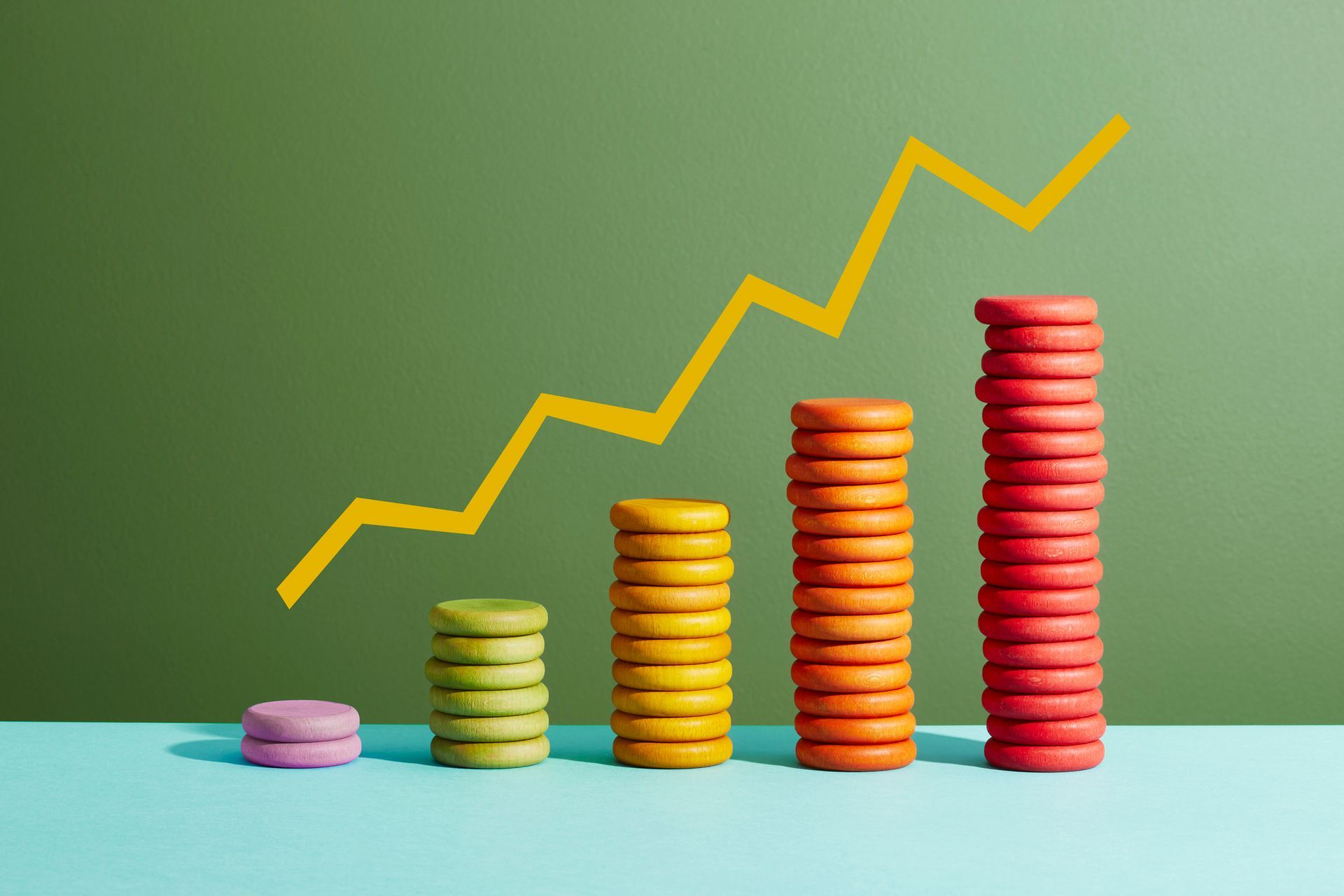 Colorful stacked coins with an upward trend line symbolizing positive cash flow growth.