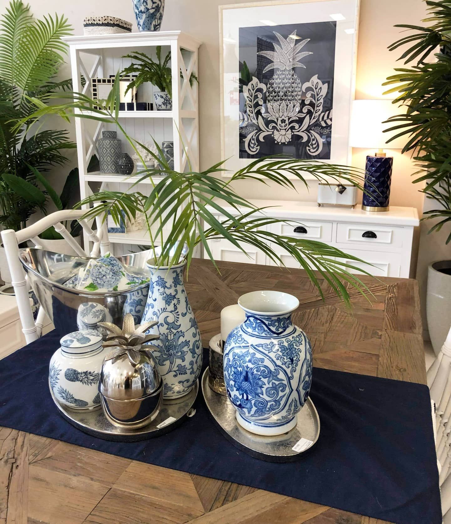 Blue-and-white Vases on Trays on a Dining Table With a Navy Runner, in a Bright Room With Framed Art and Plants — Tropic Living in Palm Cove, QLD