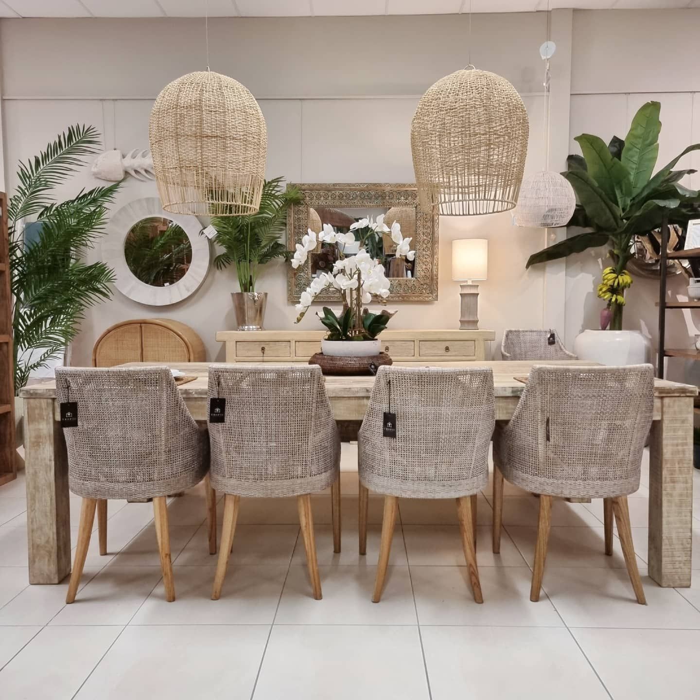 Stylish Dining Room With a Wooden Table, Woven Chairs, Hanging Pendant Lights, and Lush Green Plants — Tropic Living in Palm Cove, QLD