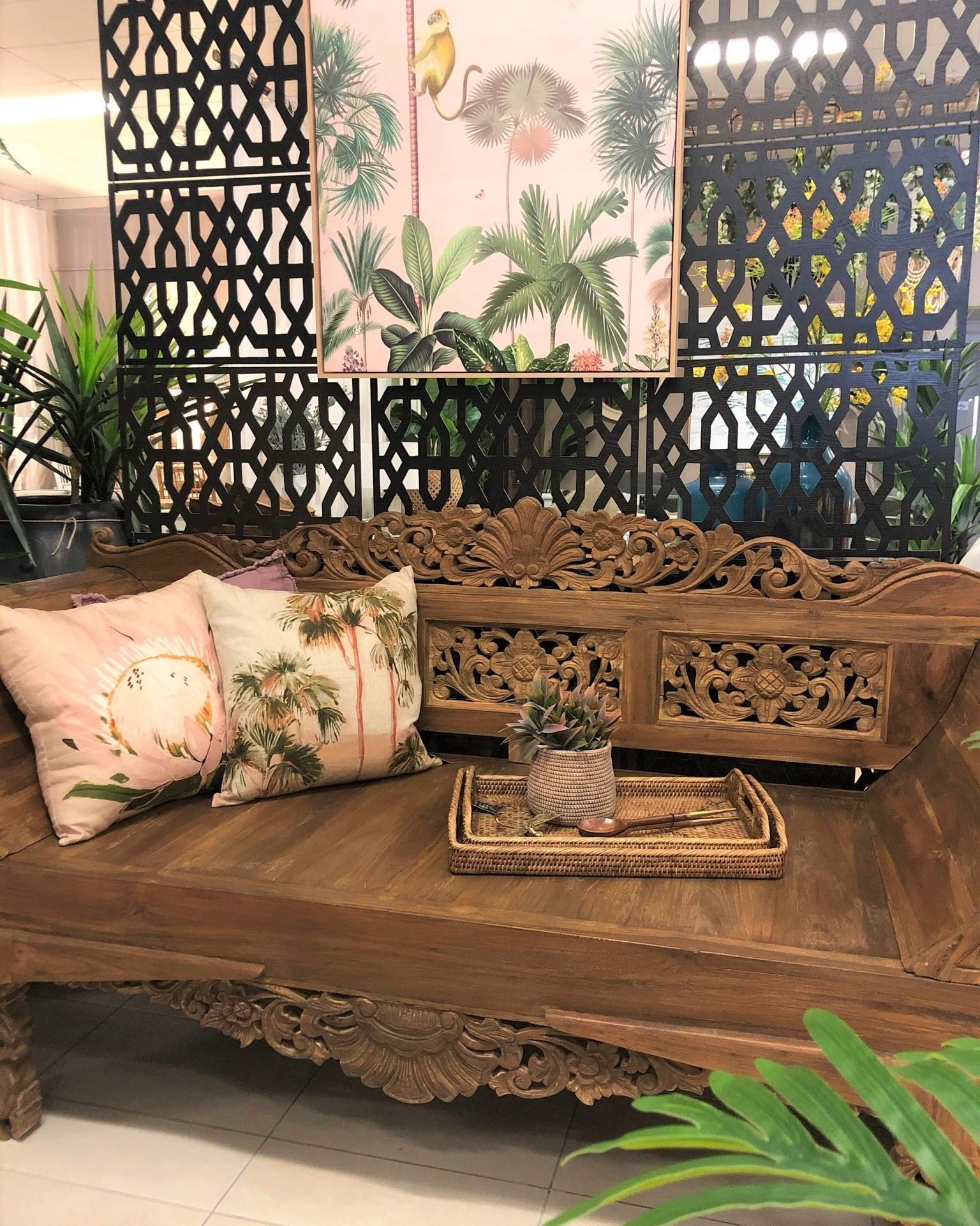 Ornate Carved Wooden Bench With Floral Cushions in a Tropical-themed Indoor Seating Area — Tropic Living in Palm Cove, QLD