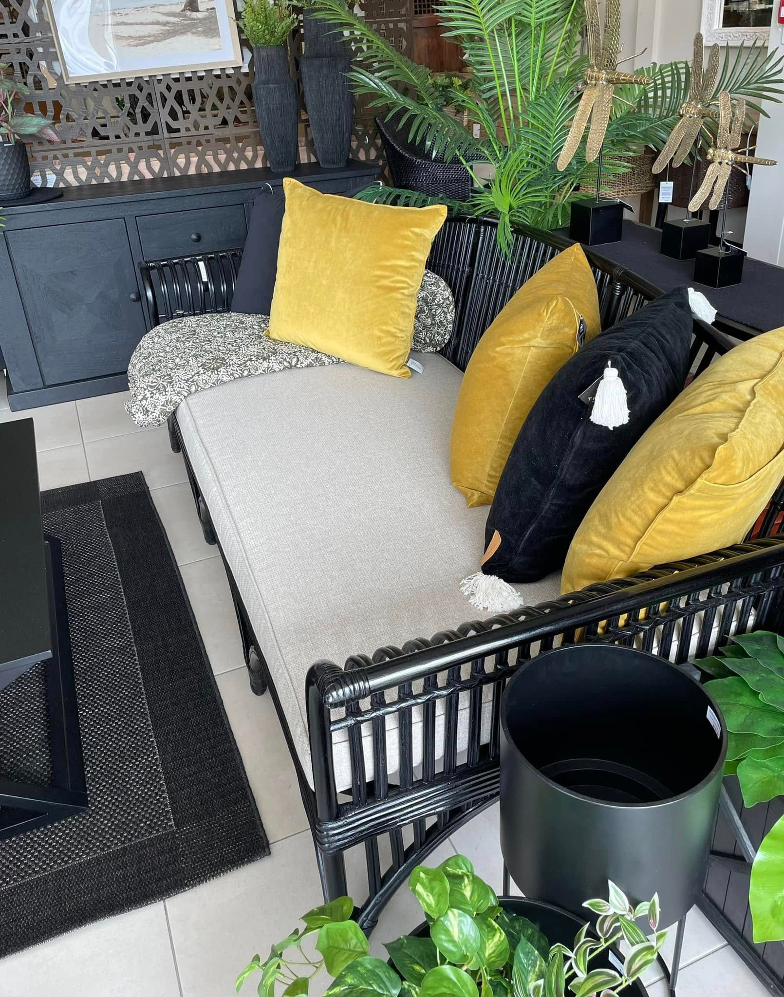Black Outdoor Sofa With Yellow and Black Pillows, White Blanket, and Potted Plants on a Patio — Tropic Living in Kewarra Beach, QLD