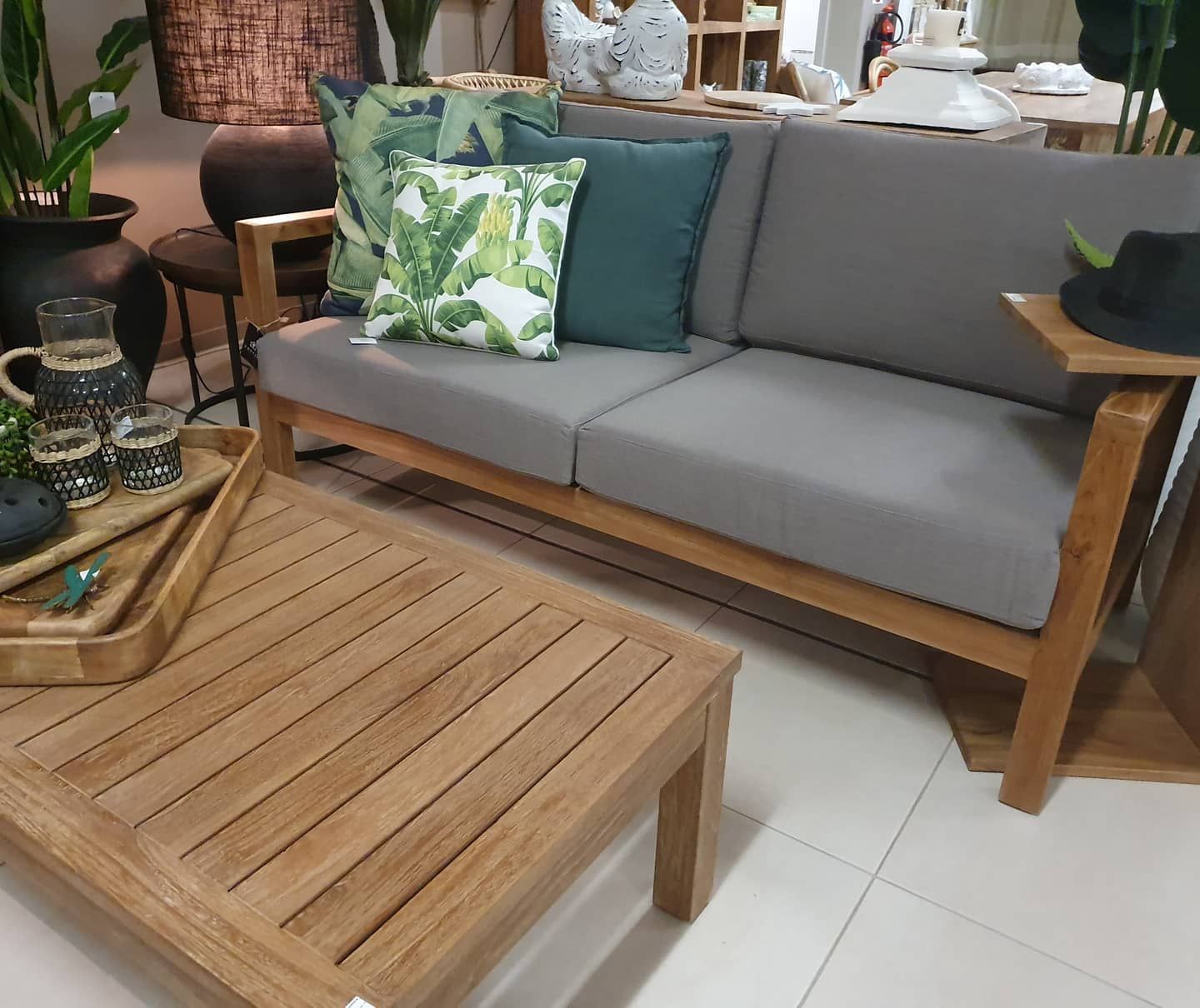 Modern Living Room With Gray Sofa, Green Pillows, Wooden Coffee Table, And Tiled Floor — Tropic Living in Smithfield, QLD