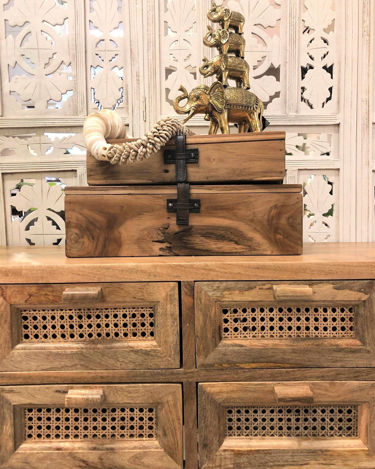 Wooden Cabinet With Carved Drawers and Decorative Items on Top Against a Patterned Wall — Tropic Living in Smithfield, QLD